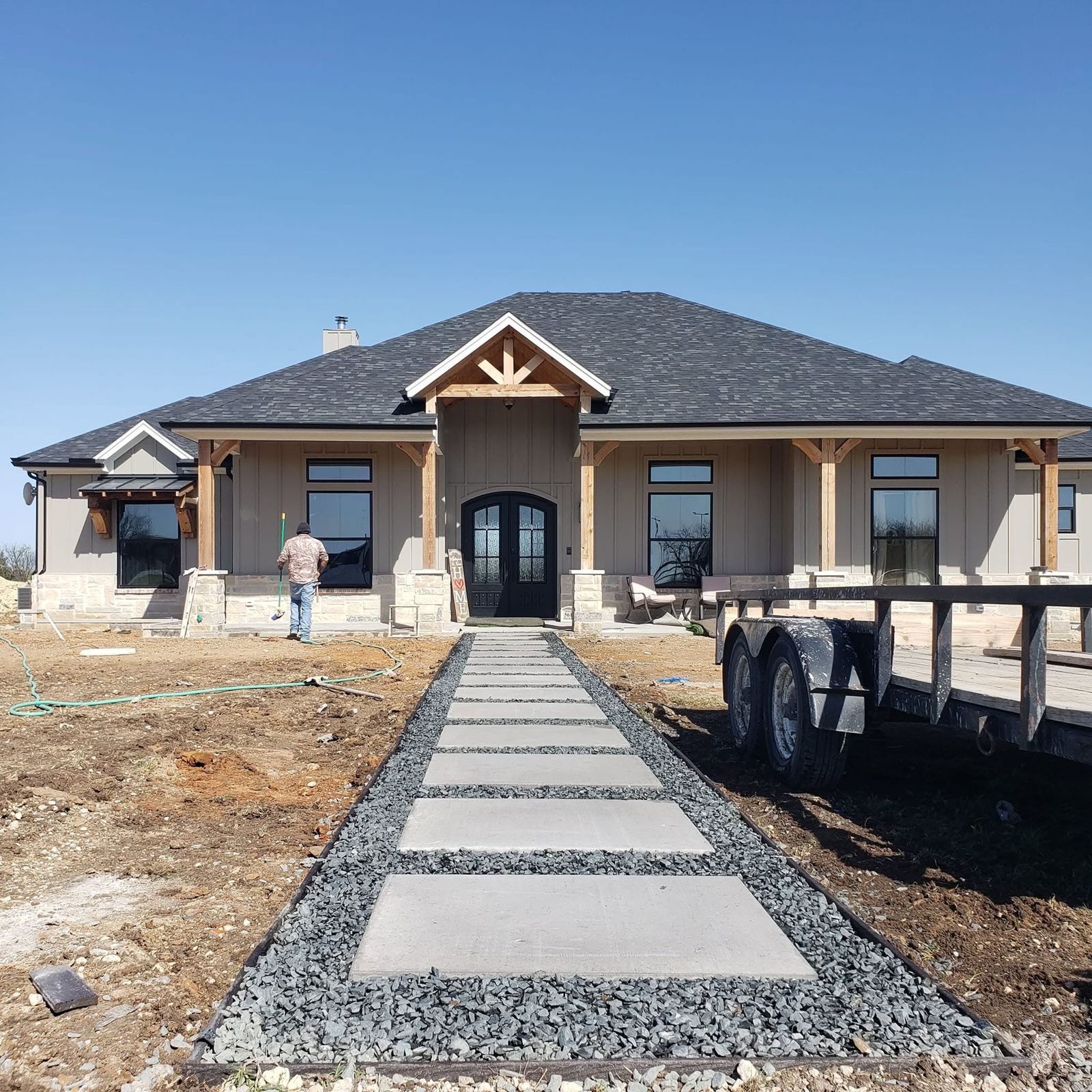 Concrete pad walkway set in gravel leading to a front entry
