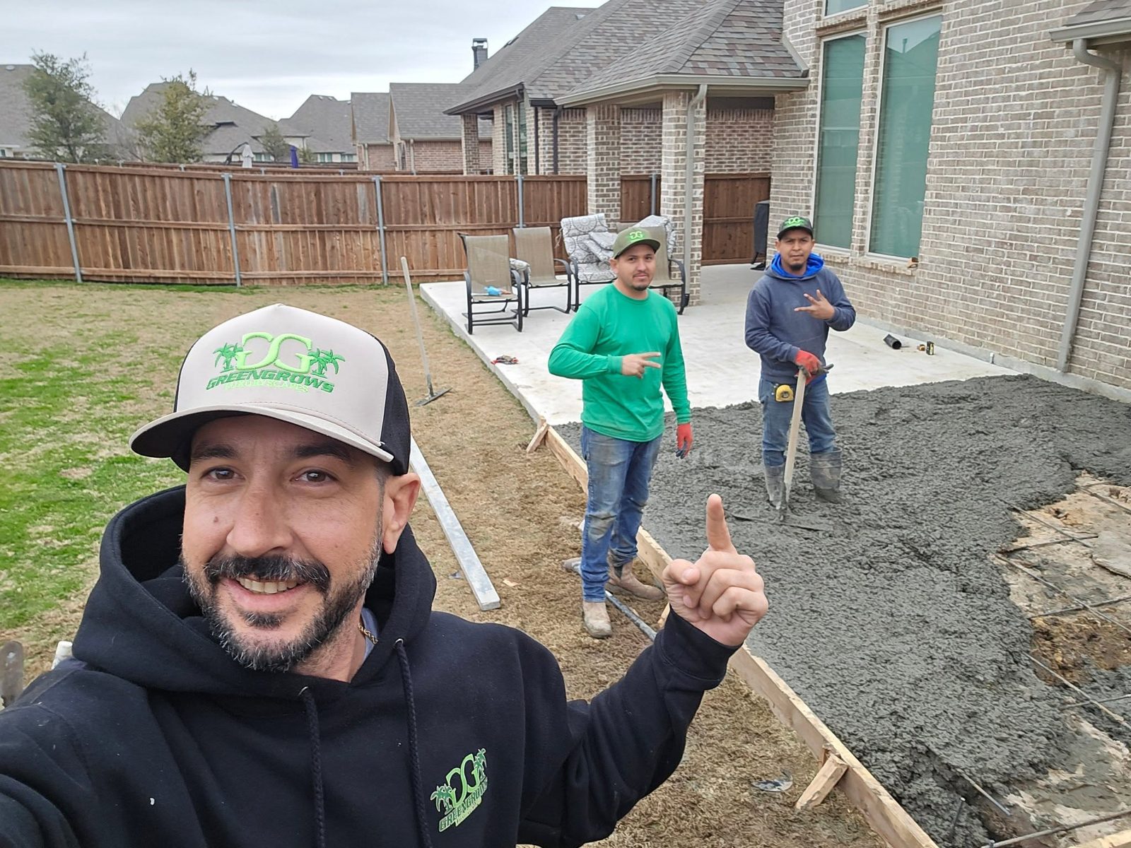 Mike Pfleger and the GreenGrows crew placing a concrete patio slab in DFW