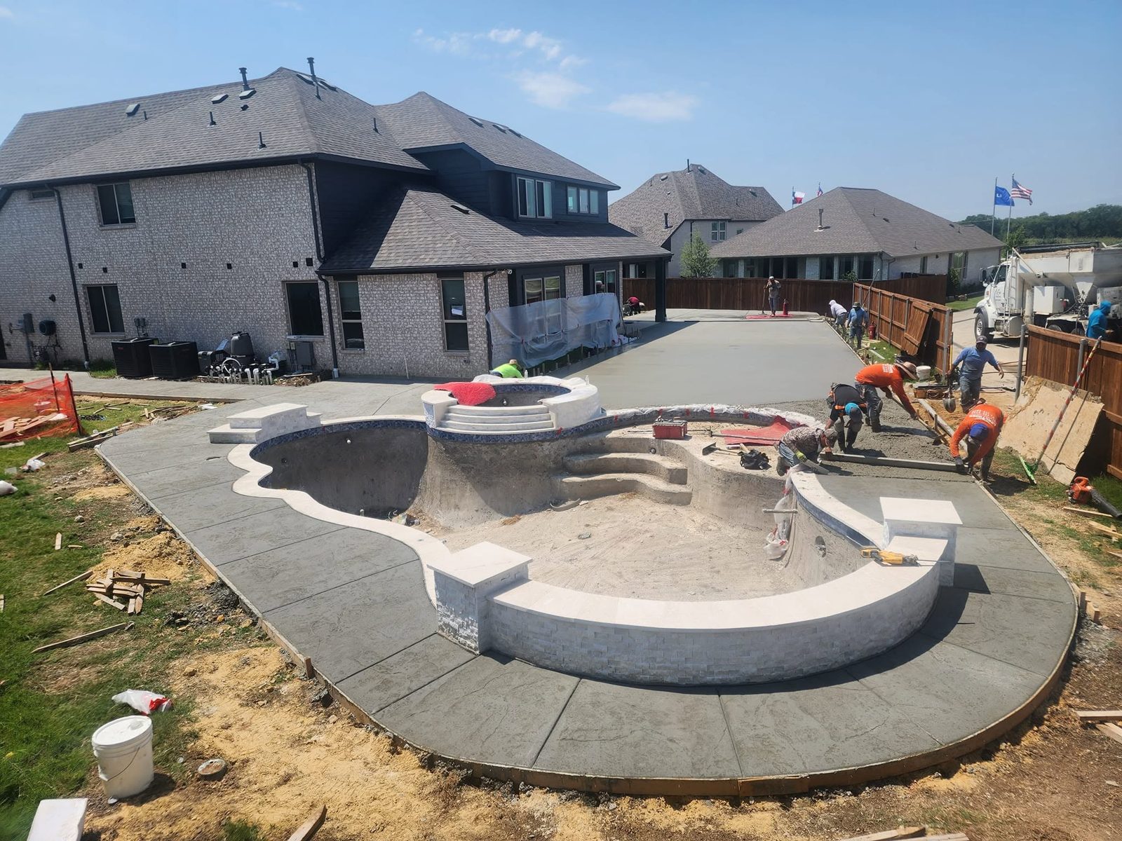 Shotcrete pool and spa shell with stamped concrete decking going in on a DFW build