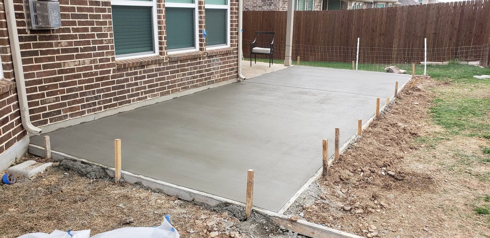 Residential concrete patio freshly poured and floated with the forms still set