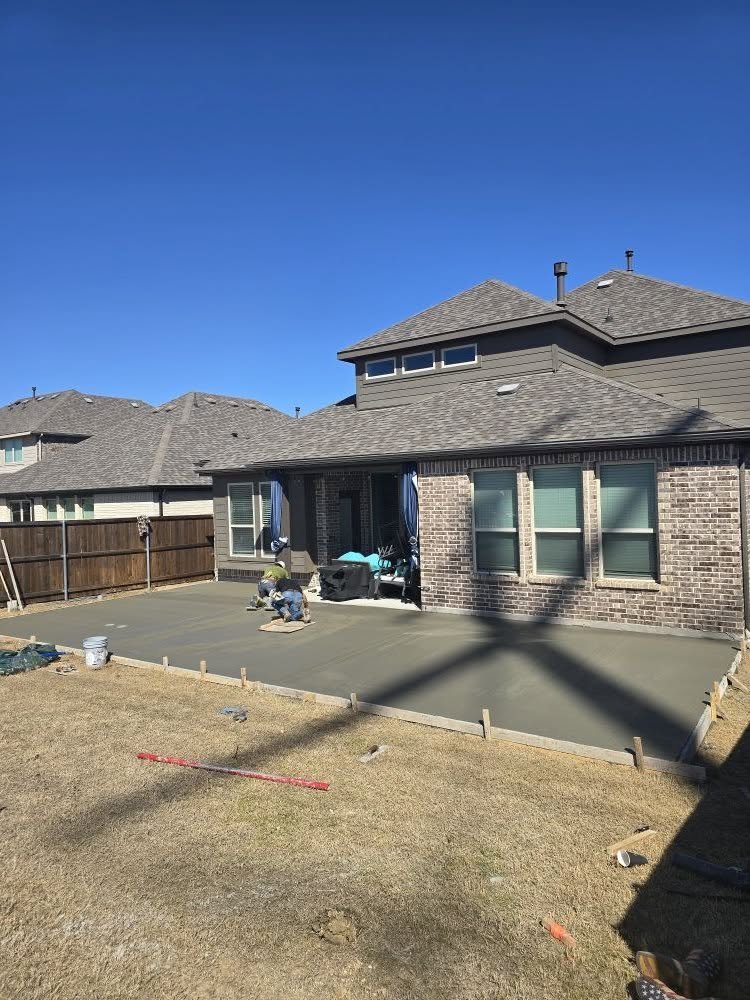 Freshly finished concrete patio slab still wet, forms set around the edge