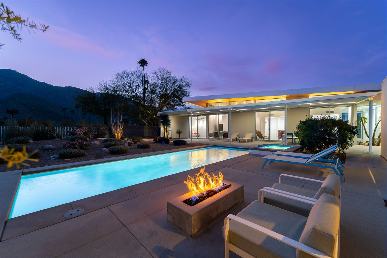 Paver pool deck with a fire feature at dusk
